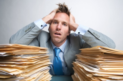 Frustrated man with tons of paperwork