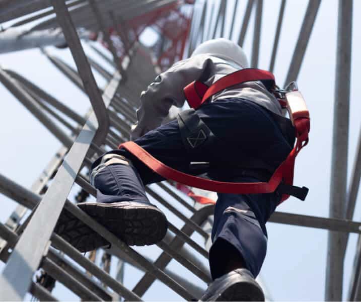 worker climbing telecom tower